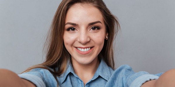 smiling woman shirt making selfie studio